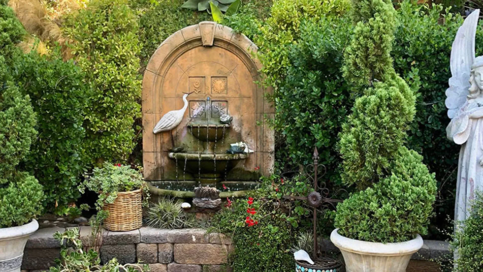 A stone fountain surrounded by greenery in the garden at the Women's Center for SoulCARE